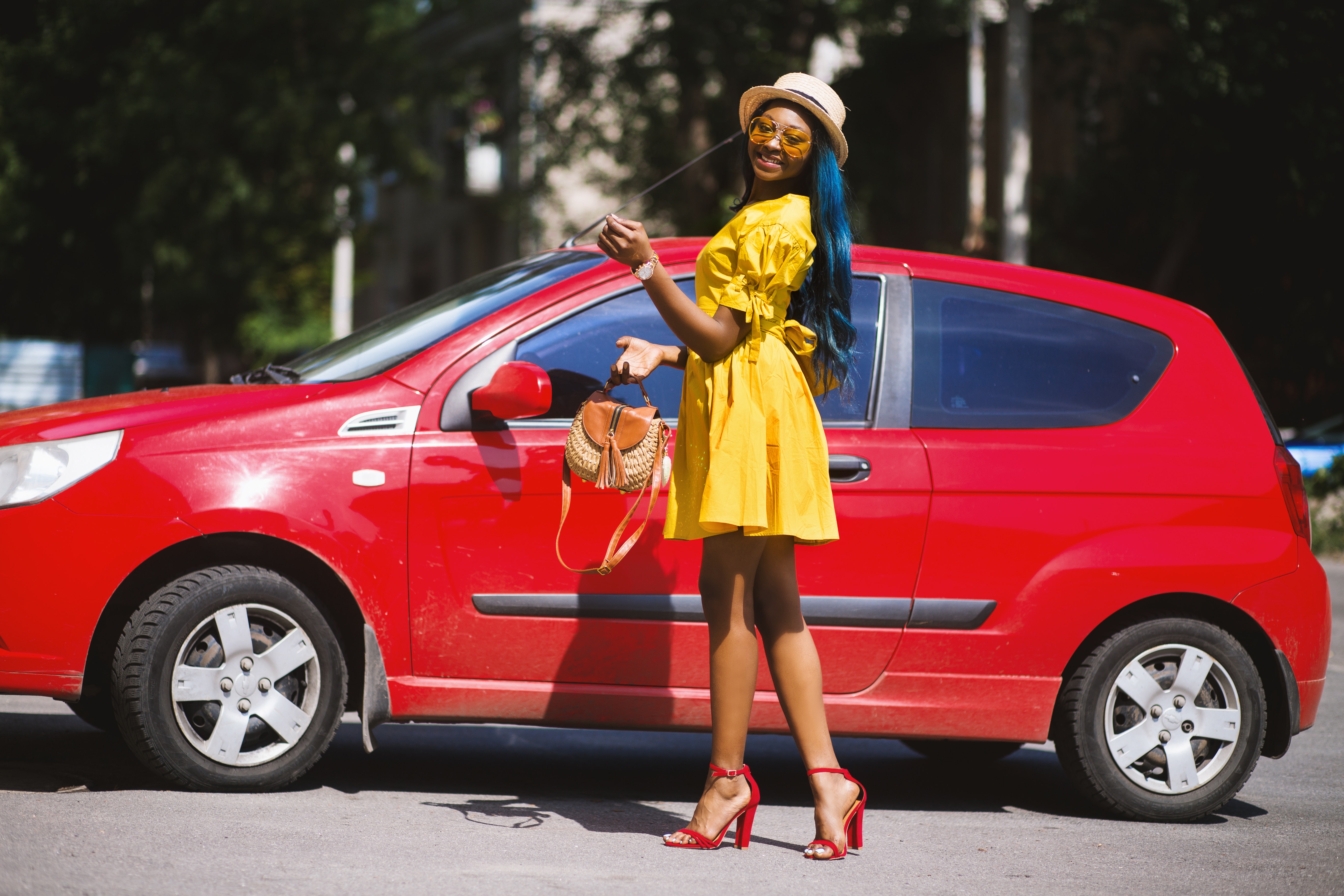 femme heureuse devant une voiture